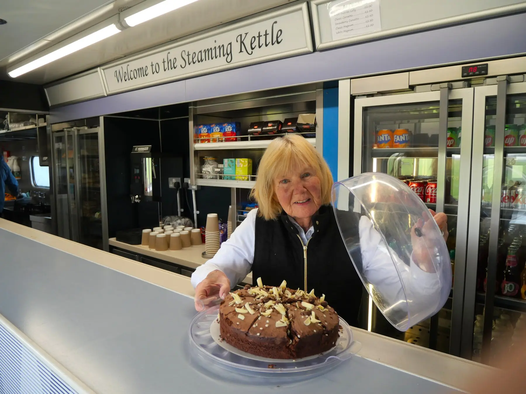 A volunteer serving cake behind the counter of the Steaming Kettle Buffet