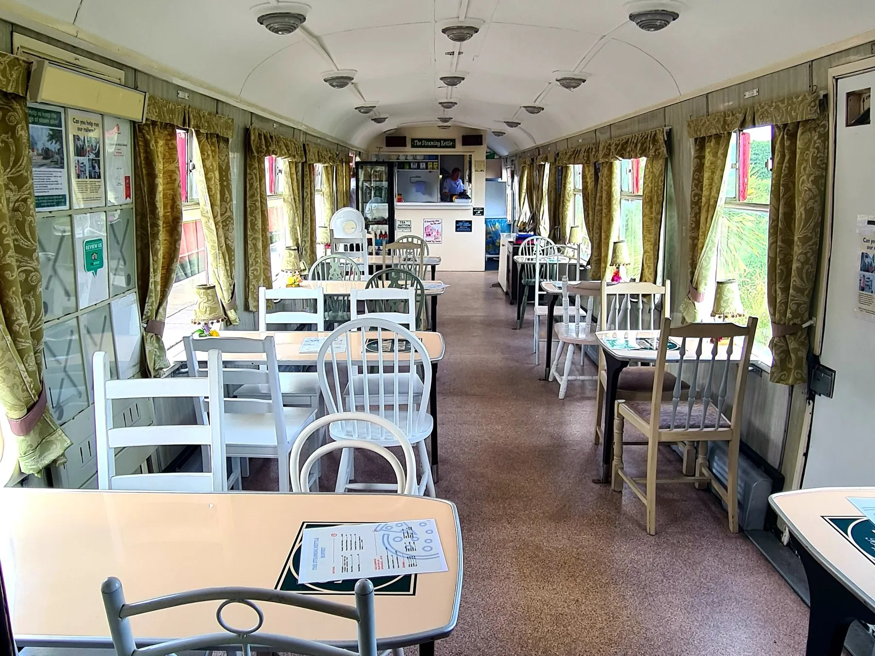 Tables and chairs laid out inside the Steaming Kettle buffet coach