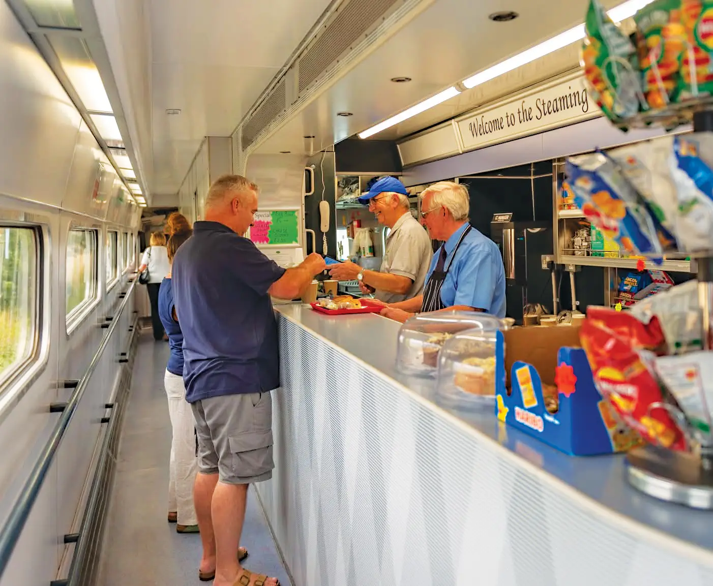 A volunteer serving cake behind the counter of the Steaming Kettle Buffet
