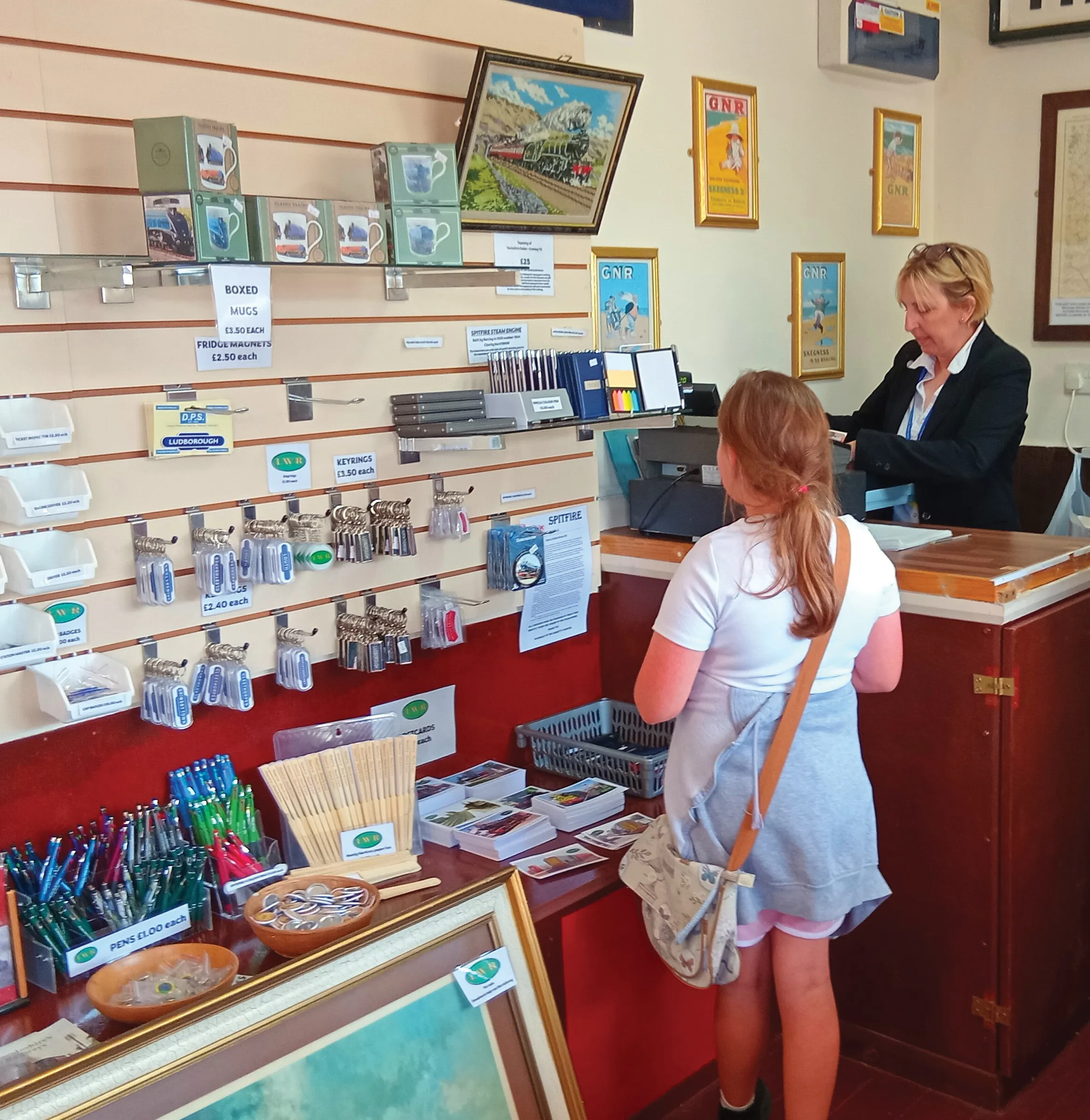 A young visitor at the gift shop counter at Ludborough Station, with keyrings, pens and postcards on display