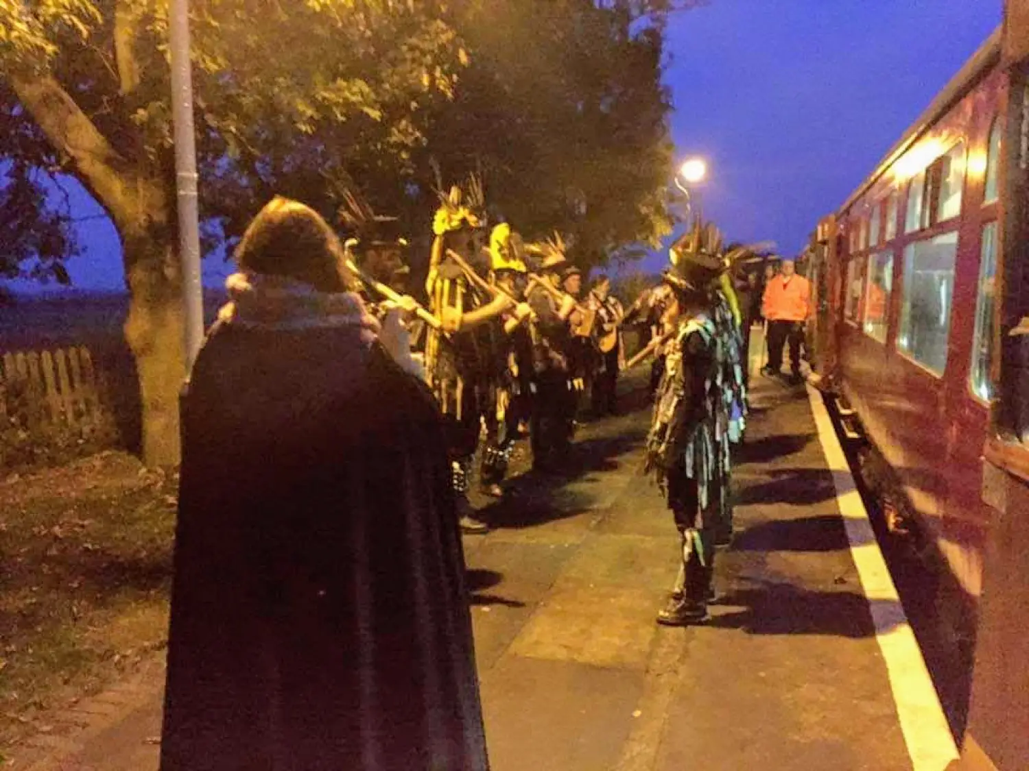 Costumed characters on the platform at dusk